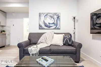 a living room with a couch and a table at *NEW* Modern Suite King Bed! Netflix! Sleeps 4! in Edmonton