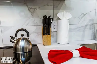 a kitchen counter with a tea pot and a red mitten at *NEW* Modern Suite King Bed! Netflix! Sleeps 4! in Edmonton