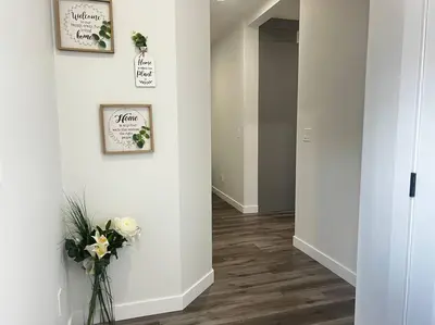 a hallway with a vase of flowers on a wall at Gorgeous 6BR New Home for Families in Nisku