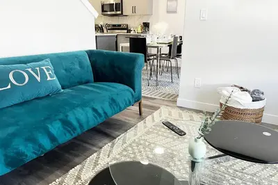 a living room with a blue couch and a table at Gorgeous 6BR New Home for Families in Nisku