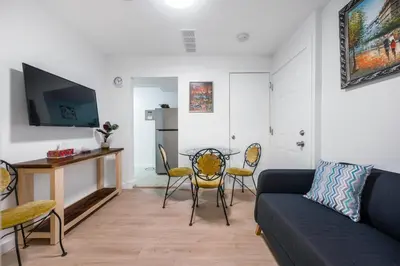 a living room with a couch and a table and chairs at Luxury Delta 2BD Suit on ground floor in Delta