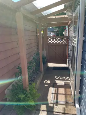 a porch with a wooden door and a fence at Luxury Delta 2BD Suit on ground floor in Delta