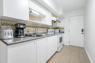 a kitchen with white cabinets and a sink at Luxury Delta 2BD Suit on ground floor in Delta