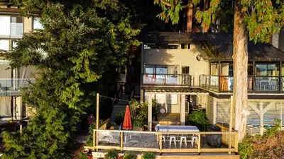 an aerial view of a house with a porch and a patio at SALT COTTAGE Waterfront Guest House with Superb Views in West Vancouver