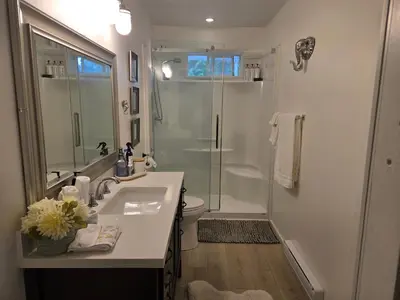 a white bathroom with a sink and a shower at Private master bedroom in a farmhouse in Nanoose Bay