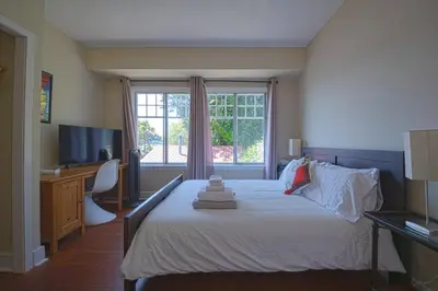 a bedroom with a bed and a tv and a window at Iconic 3-Story Waterfront 'Marina House' w/ View in Gibsons