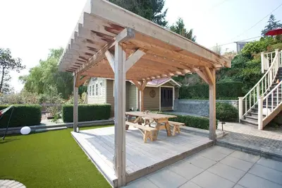 a wooden pavilion with a picnic table in a garden at Iconic 3-Story Waterfront 'Marina House' w/ View in Gibsons