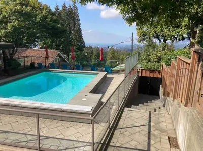 a swimming pool in a backyard with a fence at The Lions Self Contained Suite, Shared Pool, Hot Tub, Views in North Vancouver