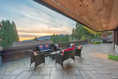 a patio with chairs and a couch and a table at Grouse Cheerful large private bedroom, bath, shared deck, pool, hot tub in North Vancouver