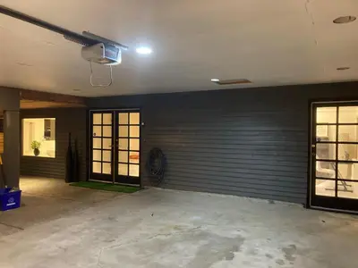 an empty garage with a garage door and a fan at Grouse Cheerful large private bedroom, bath, shared deck, pool, hot tub in North Vancouver