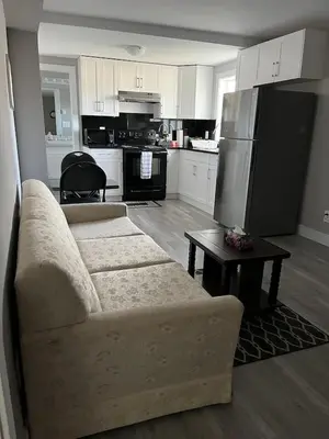a living room with a couch and a kitchen at Dugg Bed And Breakfast in Victoria