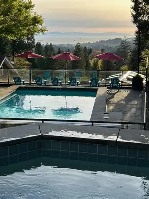 a swimming pool with chairs and umbrellas at Cypress: Private Bedroom/Bathroom/Office, with Shared Pool, Hot tub in North Vancouver