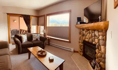 a living room with a fireplace and a tv at Wanna get away in the Rocky Mountains in Canmore