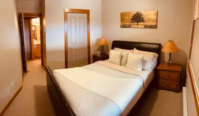 a bedroom with a bed with white sheets and pillows at Wanna get away in the Rocky Mountains in Canmore