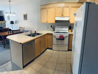 a kitchen with wooden cabinets and a white refrigerator at Wanna get away in the Rocky Mountains in Canmore