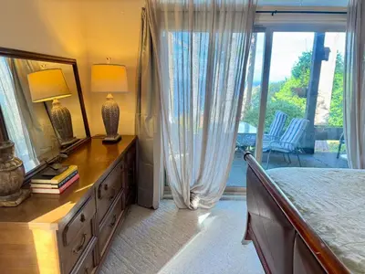 a bedroom with a bed and a dresser with a mirror at Waterfront Eagle Nest in Nanaimo