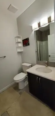 a bathroom with a toilet and a sink and a mirror at Delightful 1-bedroom Private Suite in a New Home in Calgary