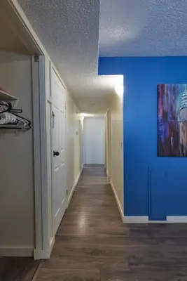 a hallway with a blue wall in a house at 2bedroom suite w/ great access into & out the city - 7818 in Calgary