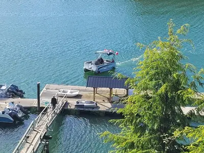 a boat is docked at a dock in the water at Argo's Landing in Bamfield