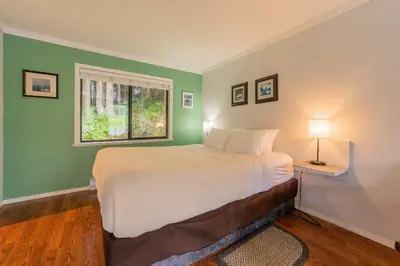 a bedroom with a large bed and a window at The Cabins at Alert Bay in Alert Bay