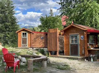 a wooden cabin with a red chair in front of it at Funky Bunky in Nelson