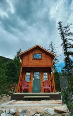 a log cabin with two chairs in front of it at Boho Bungalow in Nelson