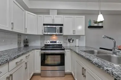 a kitchen with white cabinets and a stove and a sink at Stay In The Okanagan - Copper Sky, West Kelowna in West Kelowna