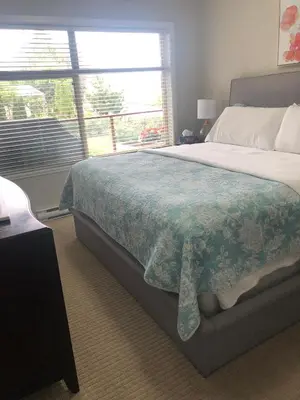 a bedroom with a large bed and a window at Stay In The Okanagan - Copper Sky, West Kelowna in West Kelowna