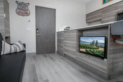 a living room with a flat screen tv on a wall at Top Floor Lakeshore Views Near Skiing in Vernon