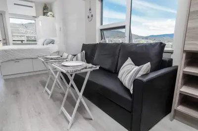 a living room with a black couch and a table at Top Floor Lakeshore Views Near Skiing in Vernon