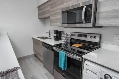 a kitchen with a stove and a microwave at Top Floor Lakeshore Views Near Skiing in Vernon