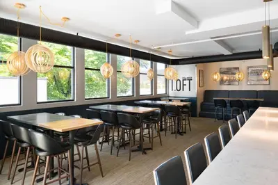 a restaurant with tables and chairs and windows at Four Points by Sheraton Penticton at the Convention Centre in Penticton
