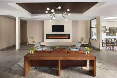a living room with a table and a fireplace at Four Points by Sheraton Penticton at the Convention Centre in Penticton