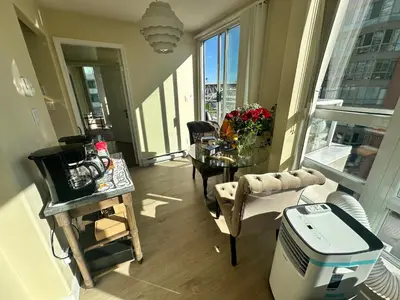 a living room with a table and chairs in a room at Penthouses of Beach Ave in Vancouver