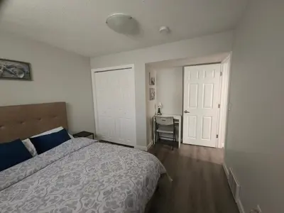 a bedroom with a bed and a desk in it at Cozy 2 Bedroom Suite, Queen Beds, Near the Airport in Edmonton