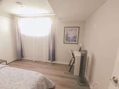 a bedroom with a bed and a desk and a window at Cozy 2 Bedroom Suite, Queen Beds, Near the Airport in Edmonton