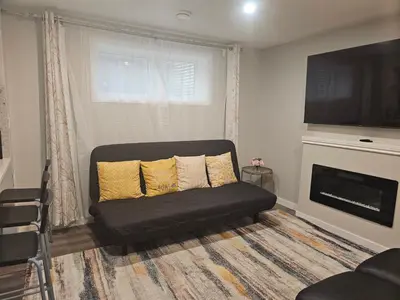 a living room with a couch and a fireplace at Cozy 2 Bedroom Suite, Queen Beds, Near the Airport in Edmonton