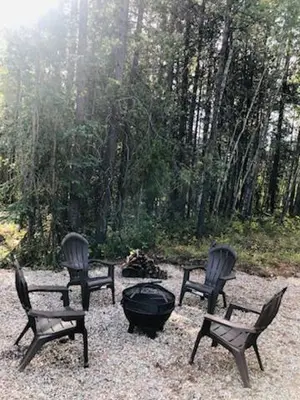 a group of four chairs around a fire pit at The Evergreen Cabin in Valemount