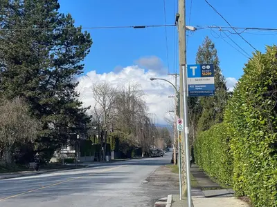 a street sign on a pole on the side of a street at Campus Haven in Vancouver