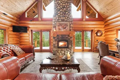 a living room with a fireplace in a log cabin at Gem by Manning Park: Luxury Loghouse “Ravenloft” in Sunshine Valley
