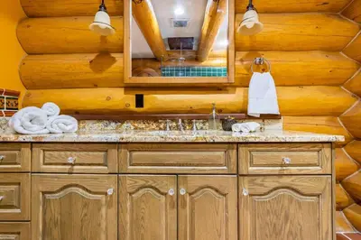 a bathroom with a sink and a mirror at Gem by Manning Park: Luxury Loghouse “Ravenloft” in Sunshine Valley