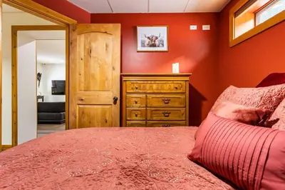 a bedroom with a bed and a wooden dresser at Gem by Manning Park: Luxury Loghouse “Ravenloft” in Sunshine Valley